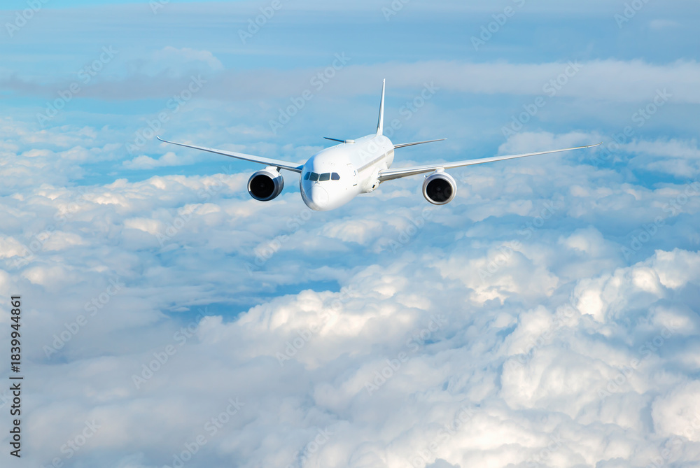 Obraz premium White passenger airplane flying in the sky amazing clouds in the background - Travel by air transport
