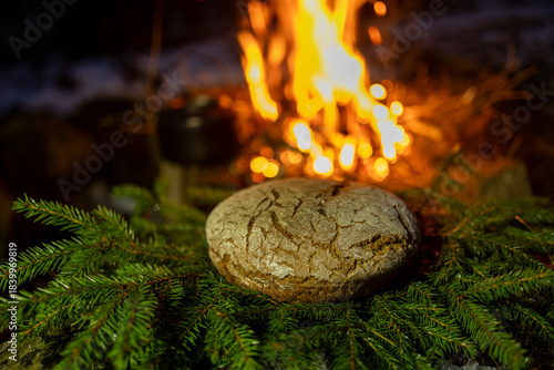 Homemade round bread against the backdrop of a bonfire