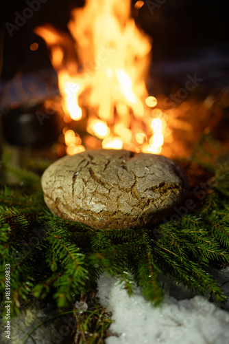 Homemade round bread against the backdrop of a bonfire