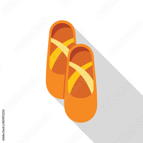 Orange ballet pointe shoes with yellow ribbons and a long shadow