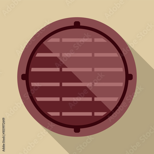 Round manhole cover creating a shadow on a beige surface