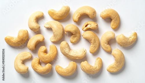 “Roasted cashew nuts scattered on a white surface.”