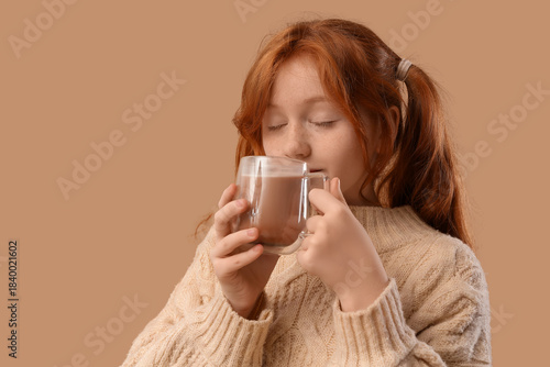 Teenage redhead girl drinki...
