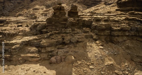 Unique geological formations create a stunning rocky landscape in a remote desert area. The natural textures and layers of rock tell a story of time and erosion in this arid environment.
