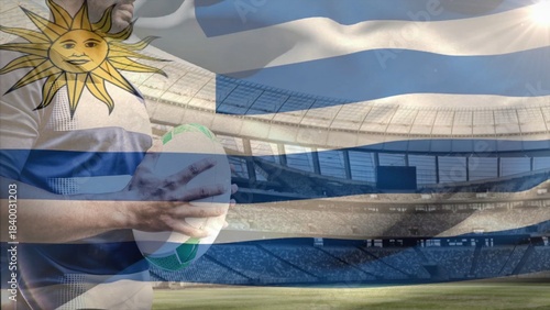 Rugby player is holding rugby ball in flat design sports ad with Uruguay flag and stadium