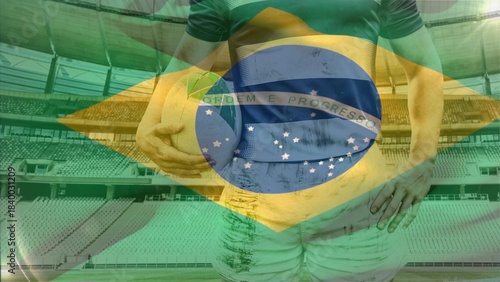 Rugby player is standing in flat sports stadium scene, holding ball under arm with flag overlay