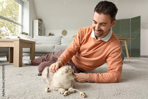 Young man playing with cute...