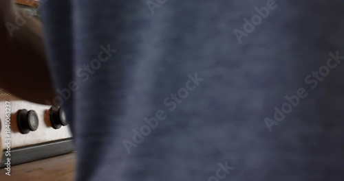 Upon entering from left, man is placing keys on wooden island, lifting lemon before exiting right