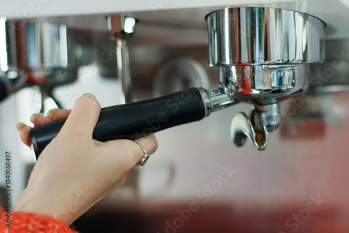 Foto Hand attaching portafilter to coffee machine close-up