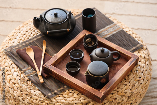Foto Black Asian tea set on pouf in living room, closeup