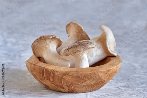 Closeup shot of a group of fresh mushrooms  lying in a wooden texture bowl