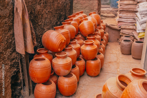 Clay pots lined up Rows of traditional clay pots arranged on the ground. Handmade earthenware commonly used in Indian households for cooking or storage.
