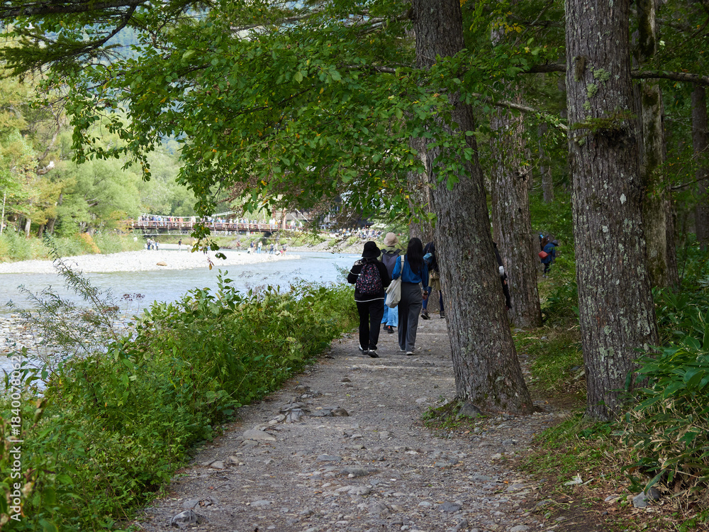Obraz premium 観光名所上高地の梓川沿岸で散歩する観光客の姿