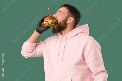 Young man eating tasty burg...