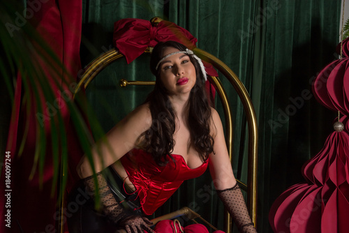 A young beautiful woman, dressed in gloves and retro-style headband-decoration stands near a luggage cart in a hotel interior.