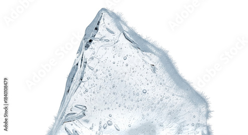 Clear ice shard with air bubbles and frosty edges on black frozen cold