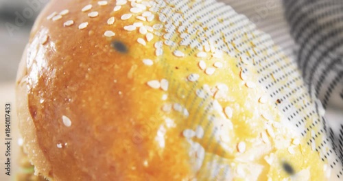 Halftone sweep revealing sesame bun, frame moving down, cheese melting, layers showing for food ad