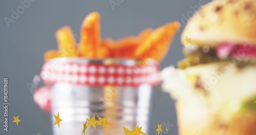 Gold stars drifting, camera shifting right, fries blurring, burger sliding into focus showing menu