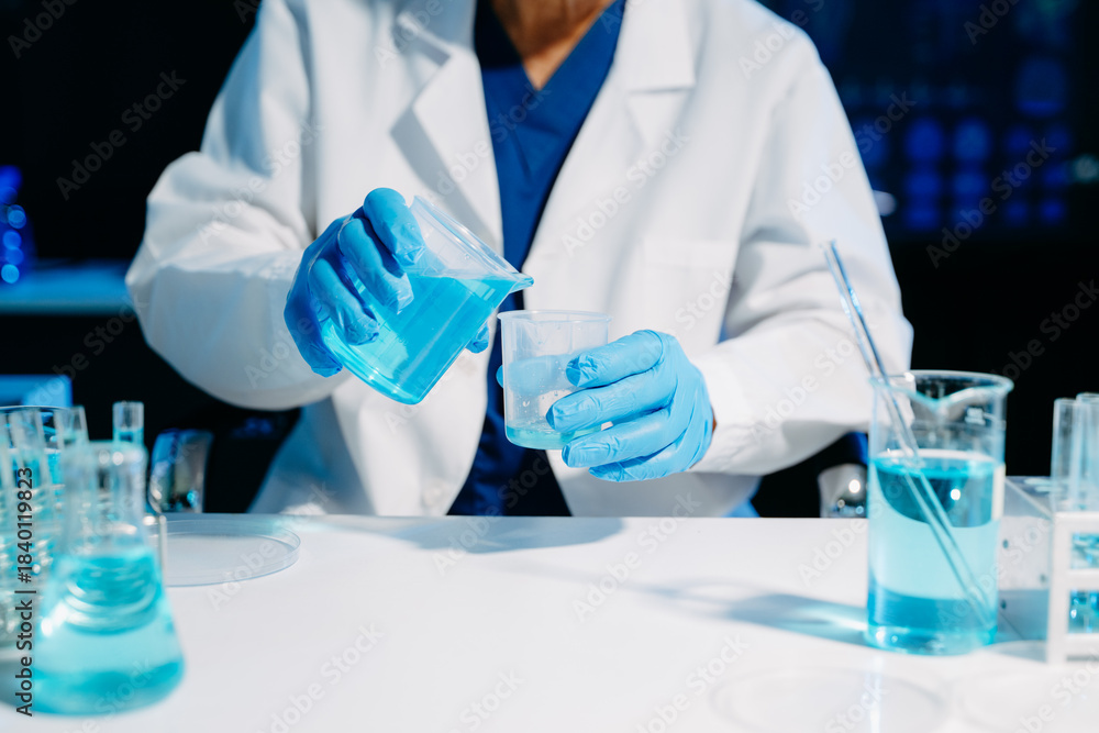 Fototapeta premium Scientist mixing chemical solutions in a modern laboratory, showcasing biotech innovation, chemistry research, diagnostics, and scientific development.