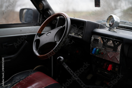 Photos View of a classic car interior with a steering wheel and control panel