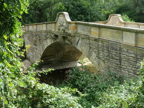 Historic baroque stone arch bridge near Erfurt-Molsdorf over the Apfelstädt river. Reflection in the river. Copyspace.