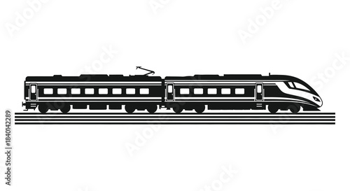 A sleek high speed train travels along the railroad tracks in a dark silhouette