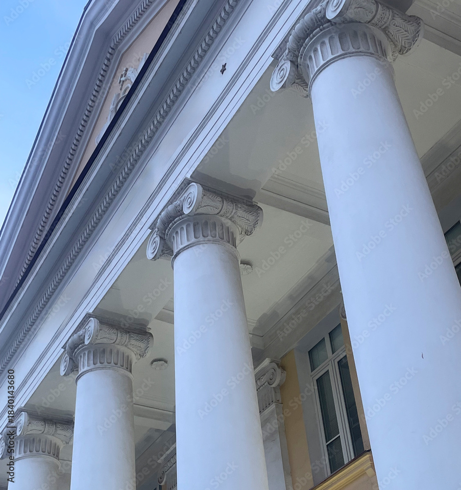 Naklejka premium The view features ornate columns against a bright sky, highlighting the structure's design