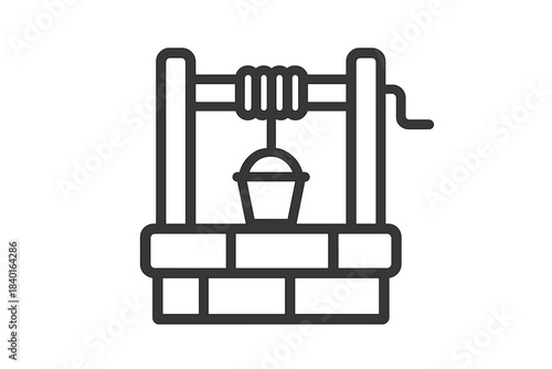 Traditional stone water well structure with a hanging bucket and winding mechanism