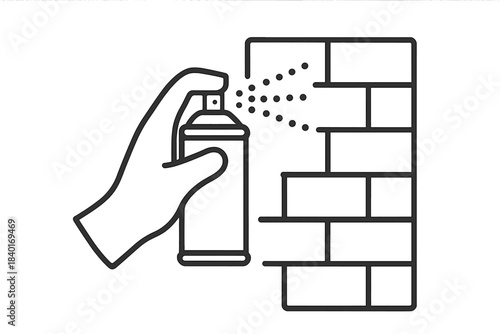 Hand holding an aerosol spray can painting graffiti art onto a textured brick wall surface