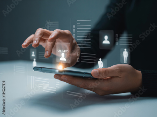 Hand holding smartphone with glowing contacts interface and user profiles mobile phone