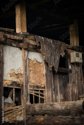 View of weathered wooden beams and crumbling brickwork tell a story of time in Tang Valley, Ogyencholing, Bumthang, Bhutan.