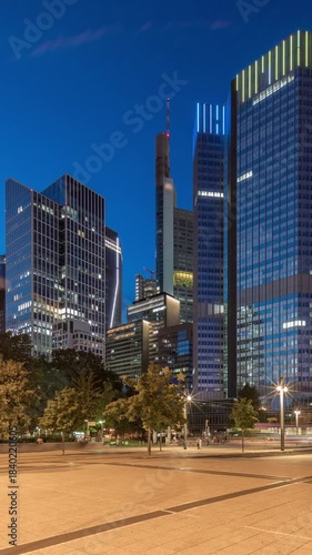 The Fairy-tale Fountain (Marchenbrunnen) before the Central European Bank in Frankfurt transitions from day to night timelapse hyperlapse, casting art-nouveau charm alongside illuminated skyscrapers