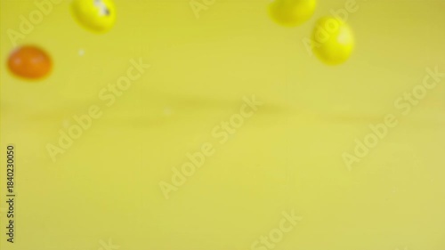 Falling colorful chocolate candies on a pastel background, super slow motion 1000 fps