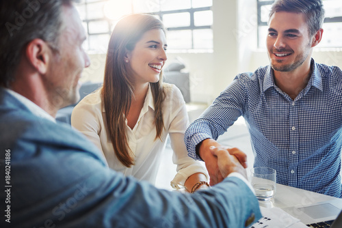 Business, people and meeting with handshake in office for real estate, agreement and auction deal. Smile, men and shaking hands for partnership, welcome client and thank you for property negotiation