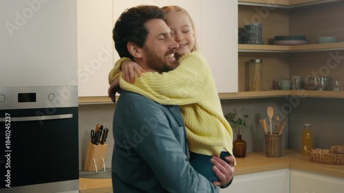 Caucasian family in kitchen positive loving dad father lifting child up rise little kid daughter spinning rotate around touch with noses love parenting at home after cooking food bonding childcare