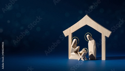Wooden nativity scene with Mary, Joseph, and baby Jesus in a stable against a starry blue background, concept for christmas, christianity and spirituality.