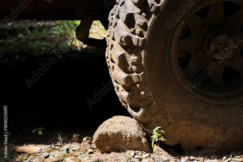 Tablou pe pânză Close up of rugged, muddy tire on large rock