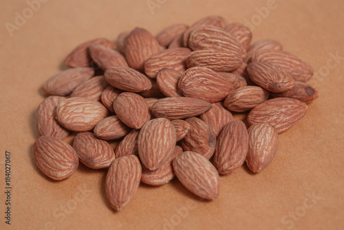 Almonds rest on a simple piece of paper, highlighting their natural texture in a clean minimal scene.