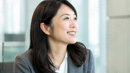 Young Asian woman smiling thoughtfully office environment hopeful adult businesswoman smile professional office portrait confident adult Asian