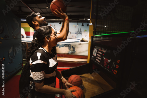 friends enjoying an indoor basketball arcade game together at a vibrant gaming zone.