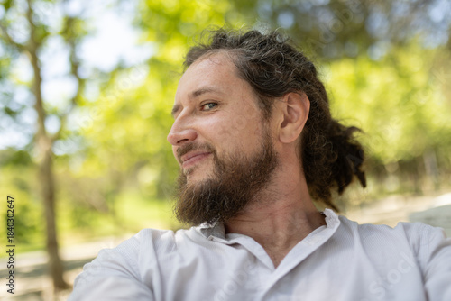 Man smiling outdoors enjoying natural park environment