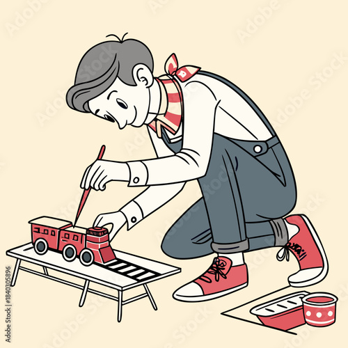 Boy painting a toy train with brush and a happy expression