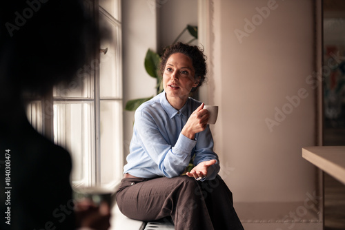 Quadro em tela Woman Conversing Over Coffee in Relaxed Indoor Setting