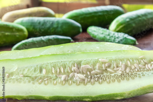Fresh farm cucumbers on an old table. A large cucumber cut lengthwise. Farm produce. Vegetable seeds.