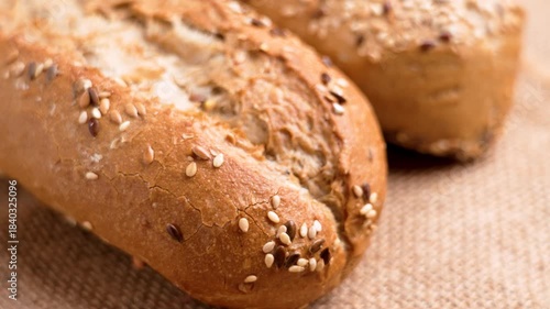Fresh bread baguettes with sesame and flax seeds on rustic rough burlap