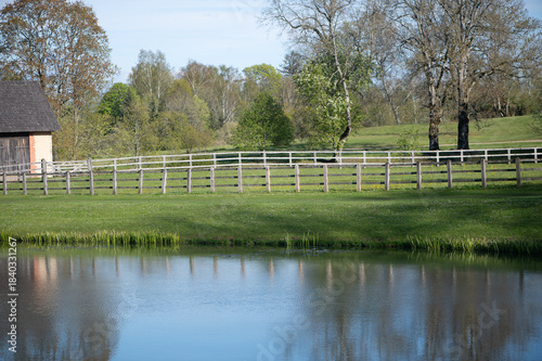 Rustic Fence Beside Quiet Latvian Countryside Pond