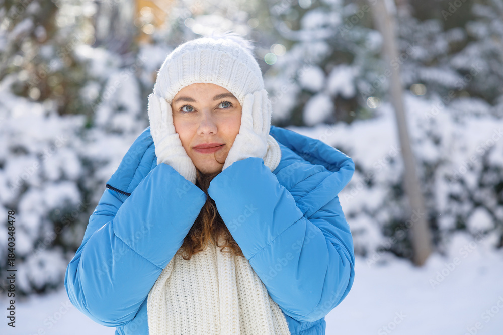 Obraz premium Young woman in blue winter jacket enjoying peaceful snowy day
