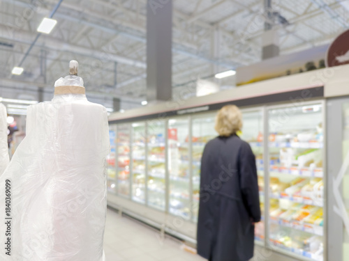  Man choosing frozen food from a supermarket freezer., reading product information
