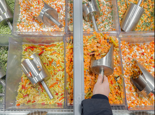 choosing frozen food from a supermarket freezer, reading product information