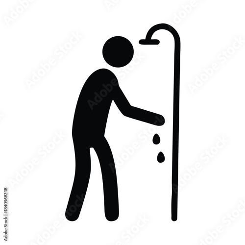 A person showers under a shower head with water droplets falling down.